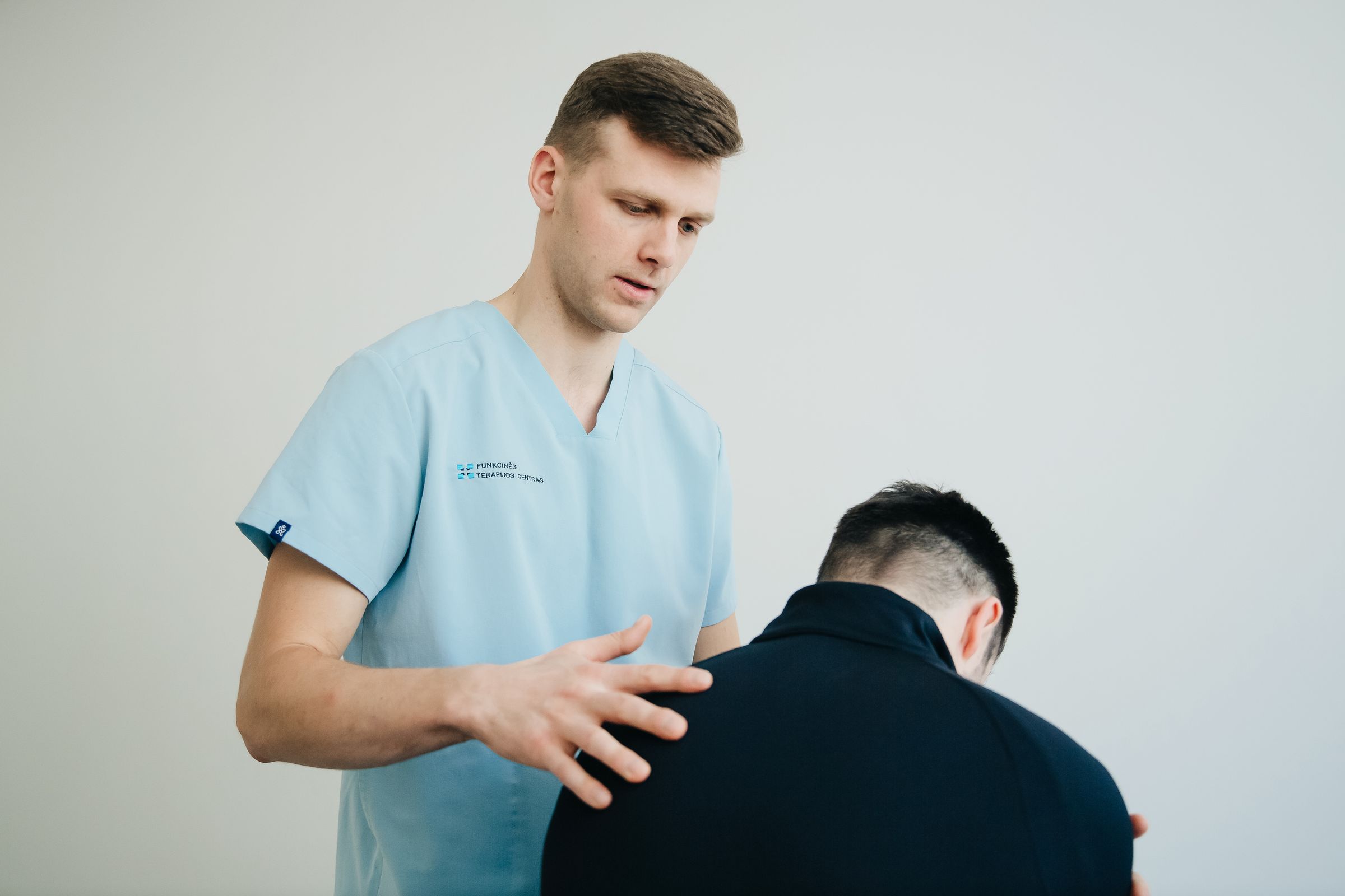 Owen assessing a patient's shoulder and upper back position