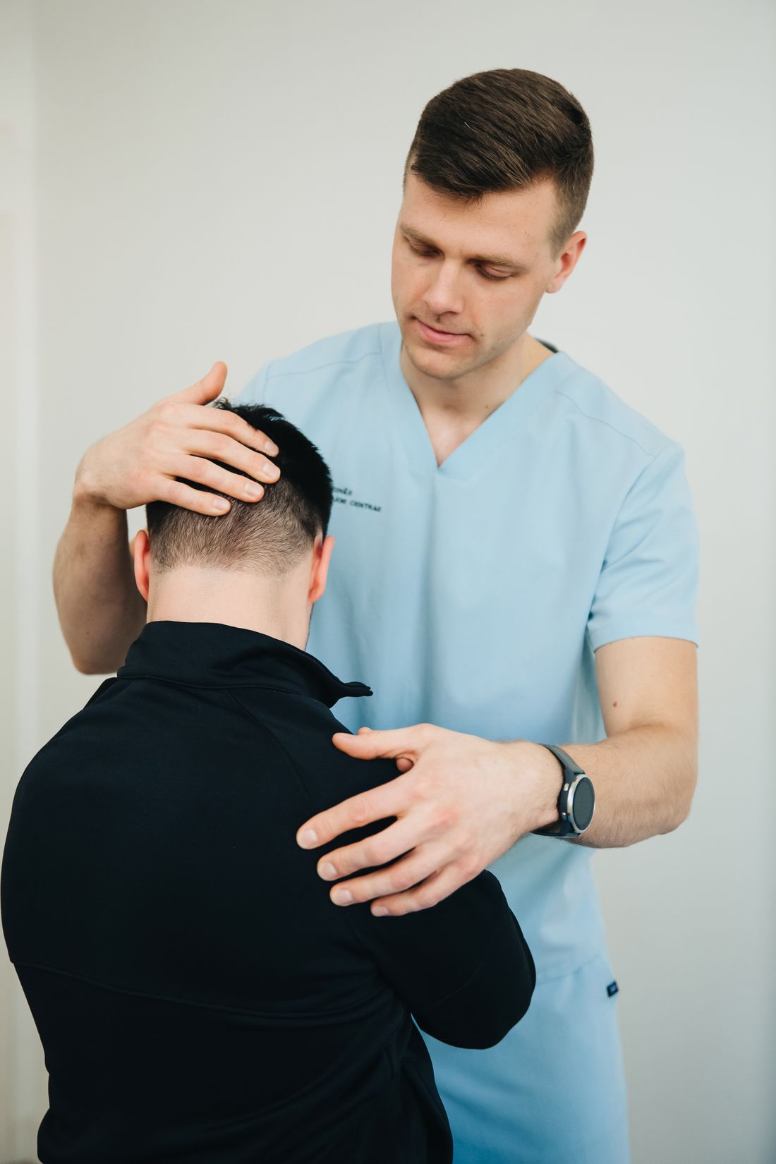 Owen supporting a patient's head and shoulder during a range test