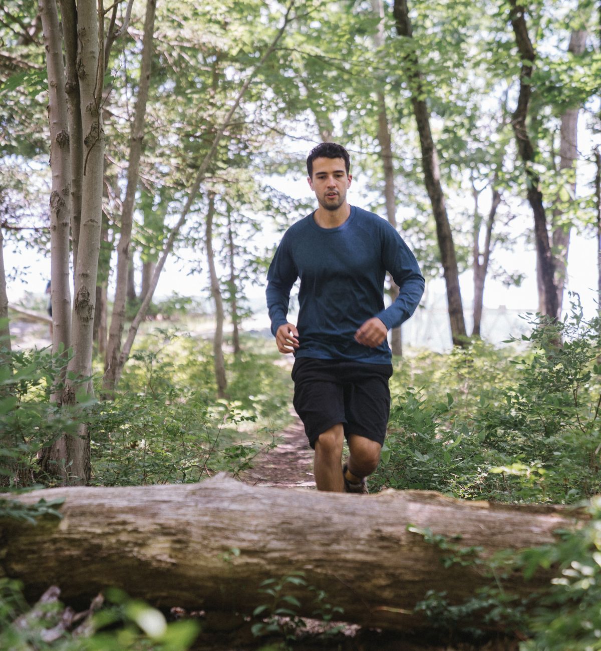 Man running along a forest trail